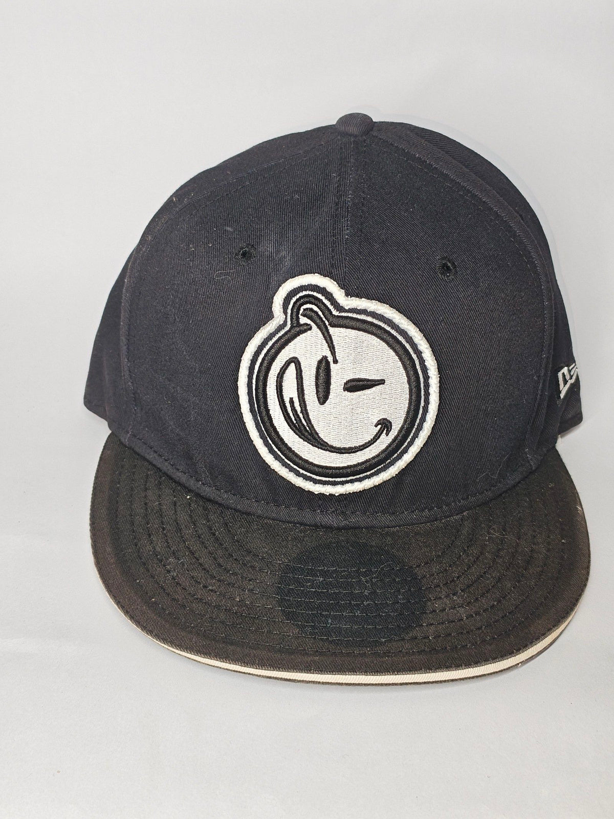 New Era black and white snapback cap with YUMS embroidered patch and cotton material.