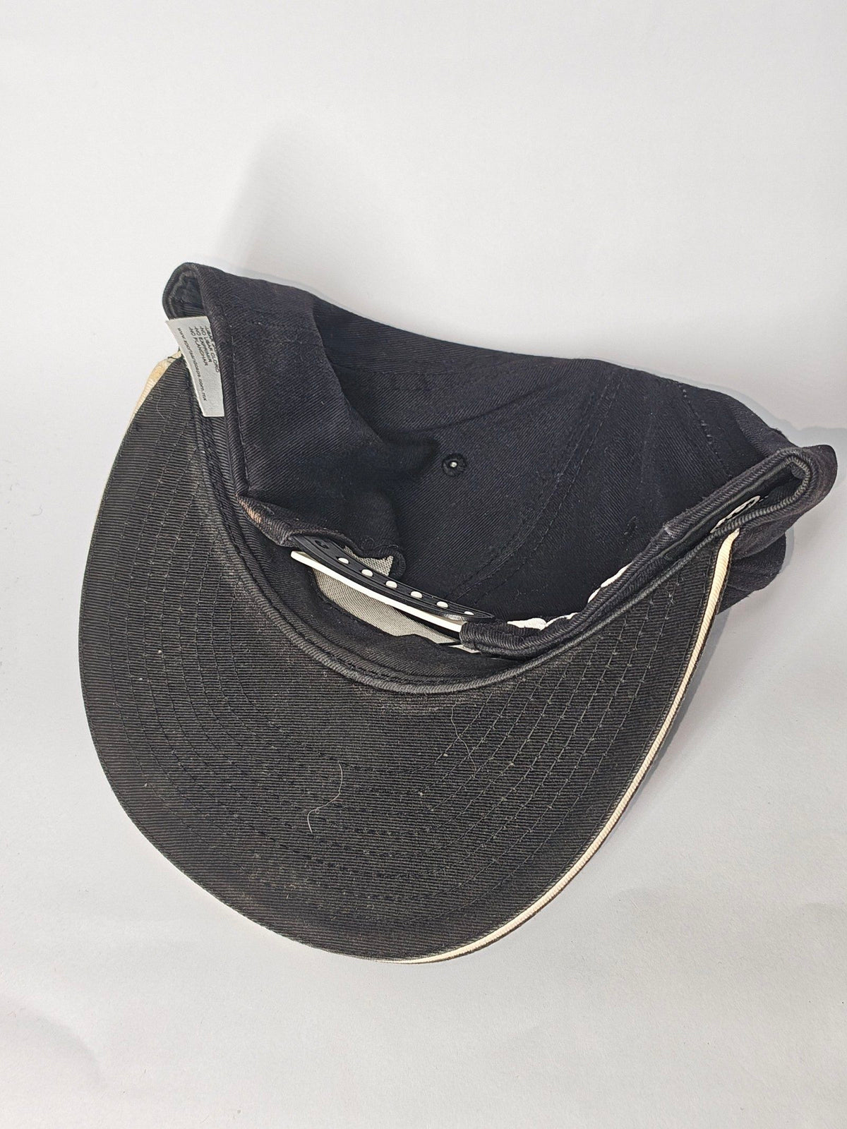 New Era black and white snapback cap with YUMS embroidered patch and cotton material.